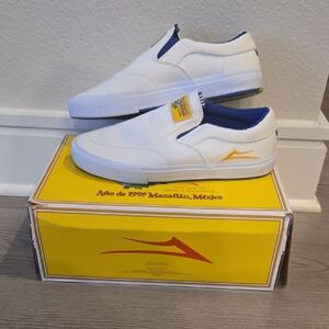 White and Blue Slip-On Sneakers by LAKAI. SKATEBOARD